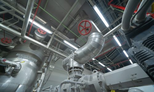 Ceiling of Industry factory. Chiller tower or cooling tower in building. System work machine. Condenser Water Supply and return pipe lines. Ventilation compressor. Water system in workshop.